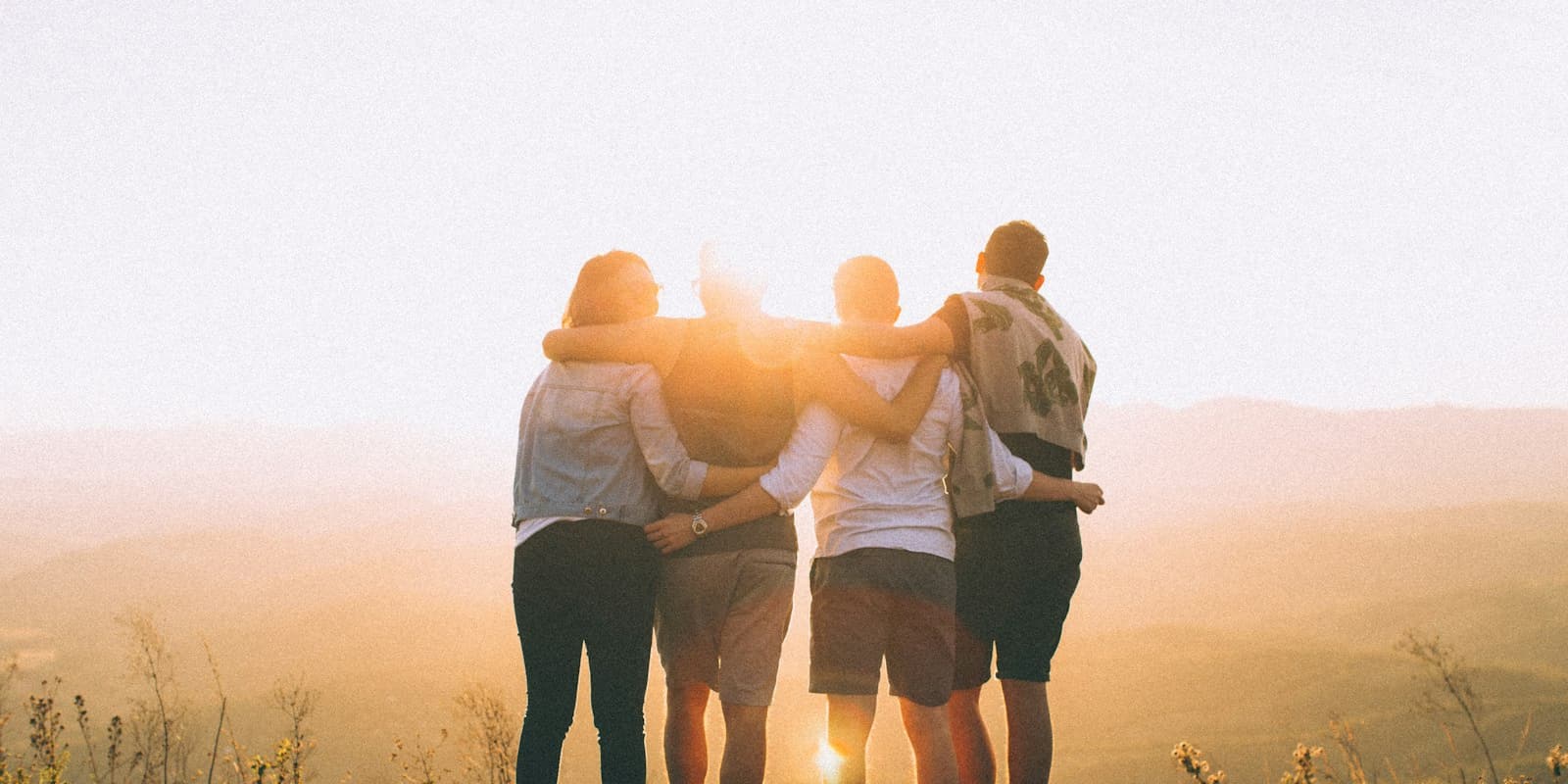 Friends embracing at sunset